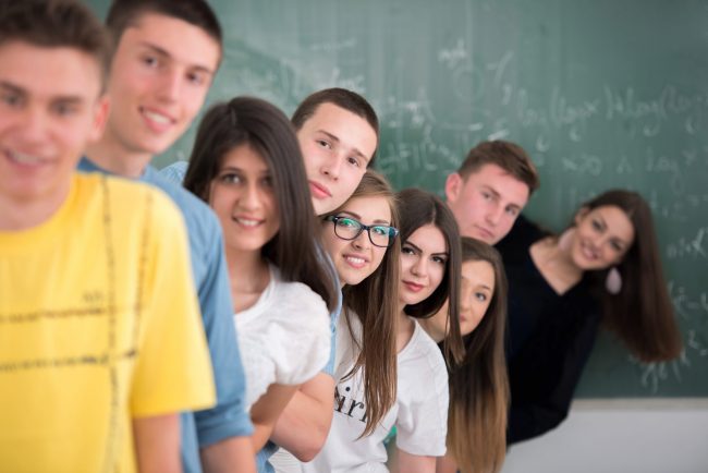 Group,Of,Teenagers,Posing,In,Classroom,Standing,In,A,Row